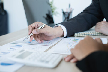 Two business leaders talk about charts, financial graphs showing results are analyzing and...