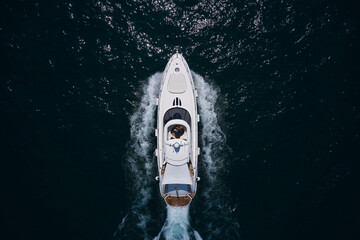White yacht on the sea aerial view. Superyacht is moving fast on the water top view. Motor Yacht in...