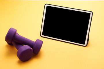 dumbbell  and smart phone in a yellow background