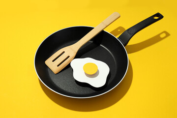 Concept of cooking on yellow background, fried egg