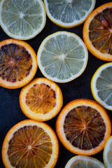 Vitamin C. Natural antioxidant cosmetics. Citrus, orange and lemon slices on dark background. Vertical image
