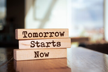 Wooden blocks with words 'Tomorrow Starts Now'.