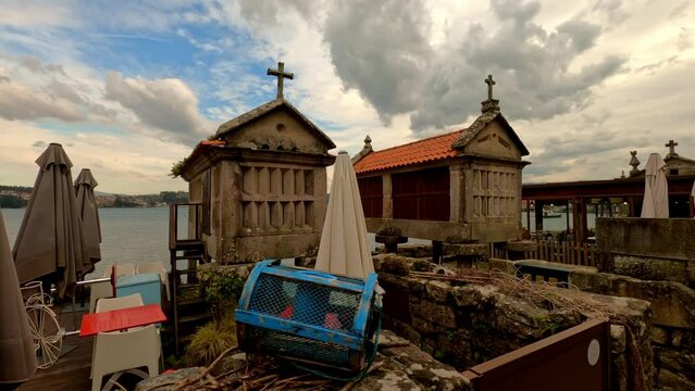 Aerial circling granaries on coast of tourist town of Combarro, Spain