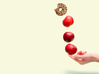 Flying levitating floating red ripe fresh apples with sweet glazed doughnut,donut in air above...
