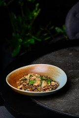 Thai buckwheat noodles with shrimp in a plate on a gray table
