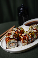 sushi roll with avocado in a white plate on a dark background macro photo