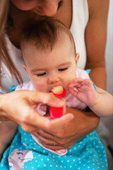 Mother feeding her little daughter vegetable puree from a spoon. Healthy eating nutrition for children.