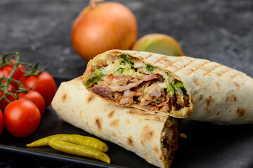 shawarma with pork on a black plate, macro photo