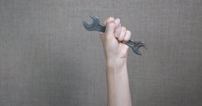 Repairing tool in woman hand. A woman hold a spanner in the room.