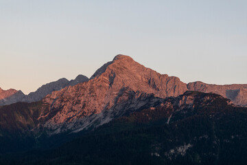 travel germany and bavaria, view at the mountain Hoher Goell at sunrise, dark trees in the forground, Bavaria, Germany