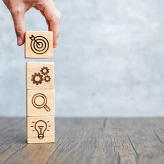 hand hold wood block with business goal, strategy, target, mission, action, objective, teamwork,...