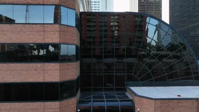 Texas and USA flags at office building in downtown. Rising aerial reveal of business and state government theme.