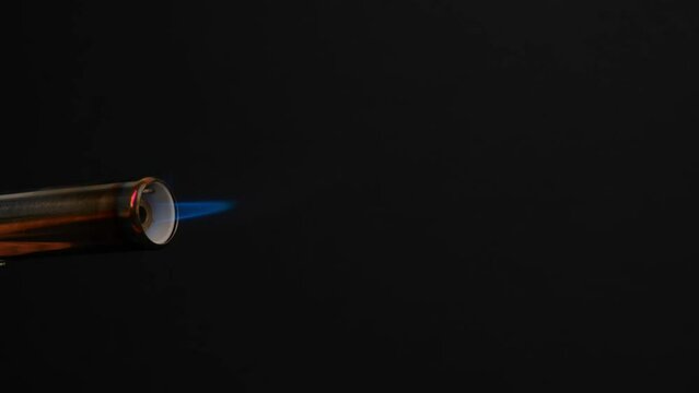 close-up of flame from the gas burner pipe burning from the nozzle on black background. blue-orange flame of the gas lights up, burns and gradually goes out. concept of gas shortage and rising prices.