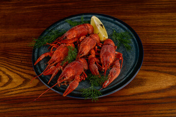 large boiled crayfish in a plate on a wooden background
