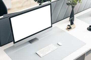 Perspective view on blank white modern monitor screen with space for your logo or text on stylish light surface with green plant and white keyboard. 3D rendering, mockup