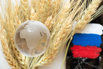 Russian flag, Ukrainian wheat and world globe lie on a white background, world famine, theft of Ukrainian grain by Russia during the war, hunger