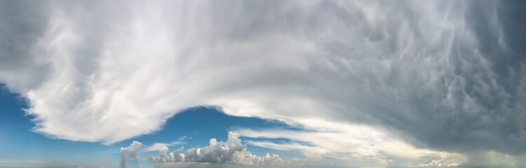 Fantastic clouds against blue sky, panorama
