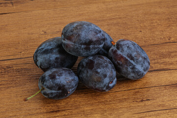 Ripe plum heap over background