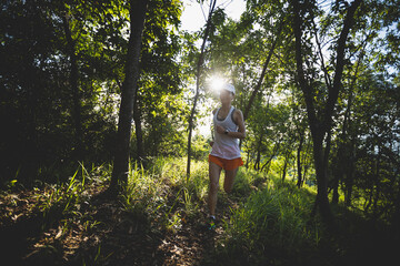 Woman runner running on forest trail