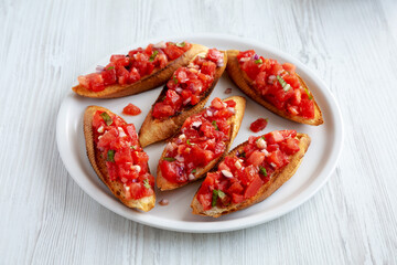 Homemade Italian Tomato Bruschetta with Basil on a Plate, low angle view.