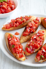 Homemade Italian Tomato Bruschetta with Basil on a Plate, low angle view.