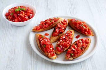 Homemade Italian Tomato Bruschetta with Basil on a Plate, side view.