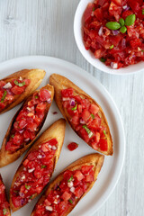 Homemade Italian Tomato Bruschetta with Basil on a Plate, top view.  Flat lay, overhead, from above. Close-up.