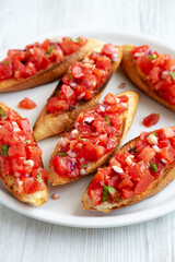 Homemade Italian Tomato Bruschetta with Basil on a Plate, side view.