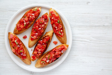 Homemade Italian Tomato Bruschetta with Basil on a Plate, top view. Copy space.
