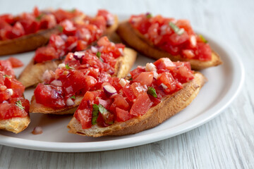 Homemade Italian Tomato Bruschetta with Basil on a Plate, side view. Close-up.