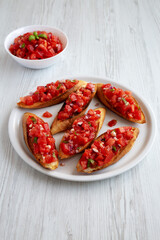 Homemade Italian Tomato Bruschetta with Basil on a Plate, side view.