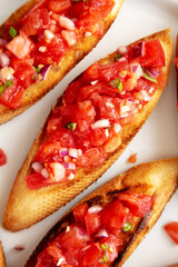 Homemade Italian Tomato Bruschetta with Basil on a Plate, top view.  Flat lay, overhead, from above.