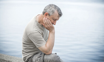 Psychology portrait of mature man, outdoor scene, concept of crisis, problems in life