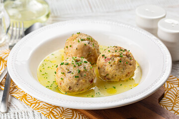 Canederli or Knödel in broth with green onion, typical pasta or dumplings for Alps, Alto Adige,...