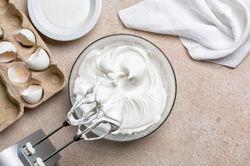 Beaten egg whites with sugar  for Meringue in a mixing bowl with an electric hand whisk. Cooking...