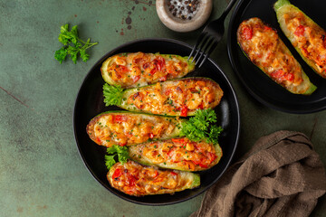 Dinner with oven baked Zucchini stuffed with chicken meat, belle peppers, tomatoes and cheese on a...