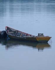 Fototapeta na wymiar an old rowing fishing boat on the river