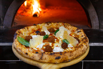 Pizza Napoletana Gourmet con ragù napoletano, provola affumicata, polpettine di carne, ciuffi di...