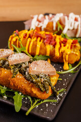 Tris di crocchè di patate fritti gourmet di una pizzeria con cheddar fuso, bacon croccante, friarielli, salsiccia, crema di pecorino e mortadella