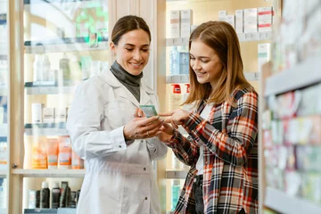 Foto op Plexiglas anti-reflex Apotheek White apothecary wearing lab coat working with customer in pharmacy