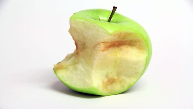 Time-lapse video showing the ageing process of a half eaten bright green apple as it turns brown