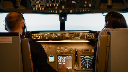 Team of aviators using dashboard buttons to takeoff with plane, starting power engine and control...