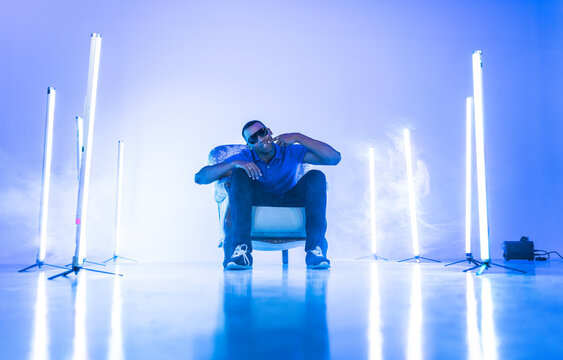 Rapper Sitting On Chair Singing At Film Set