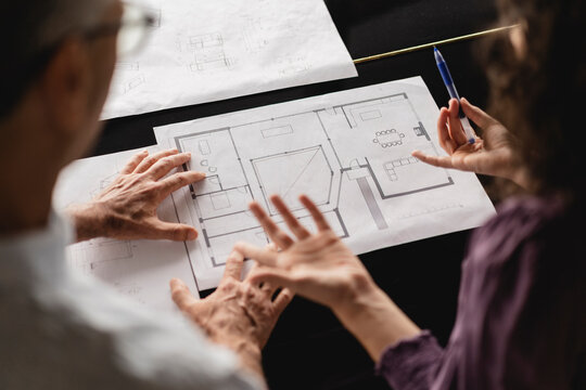 Business colleagues discussing over floor plan on table at office