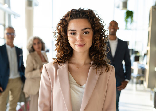 Smiling businesswoman with curly hair at office