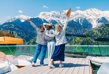 Friends standing with arms around each other in front of mountains at Lake Ritsa