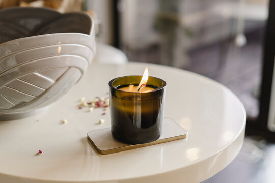 Burning scented candle on table at home
