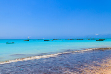 View of tropical sandy Nungwi beach and traditional wooden dhow boats in the Indian ocean on Zanzibar, Tanzania
