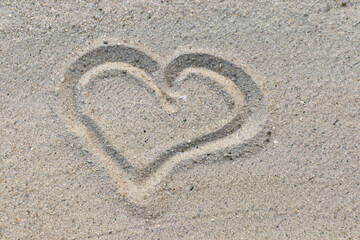 Fototapeta na wymiar Heart symbol is drawn on white sand, sandy sea beach