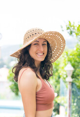 Portrait of beautiful smiling woman in wide brim straw hat